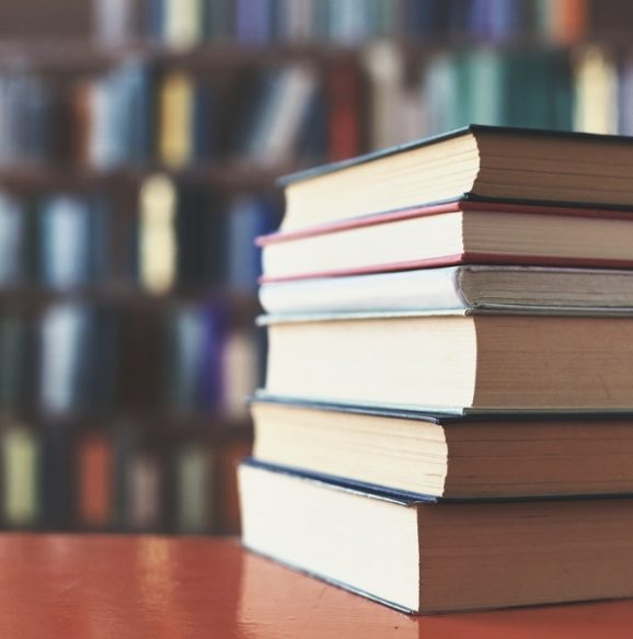 Stack,Of,Books,Against,The,Background,Of,Library,,Stack,Of